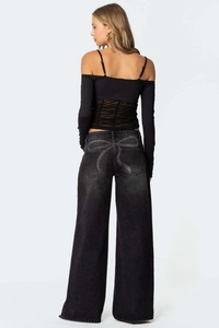 Détail de l'imprimé papillon sur la poche arrière du jean large noir pour femme mode
