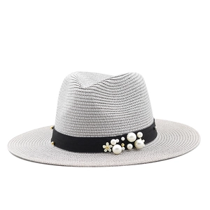 Light gray wide brim straw sun hat with black ribbon, white pearls and floral accents