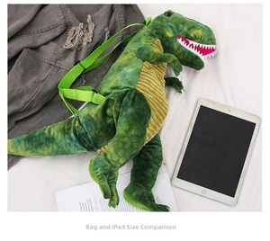 Green dinosaur plush backpack size comparison with a tablet on a white background