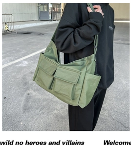 Detail of olive green canvas tote bag with multi-pocket utility design and wide shoulder strap
