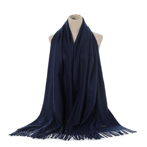 Close-up of navy cashmere scarf showing fringe detail and soft knitted fabric texture