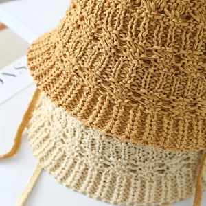 Dettaglio ravvicinato di cappelli a secchiello in paglia all'uncinetto con lacci coordinati