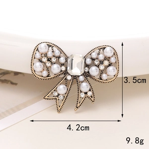 Vintage gold bow charm with white pearls and rhinestones, size 4.2cm by 3.5cm