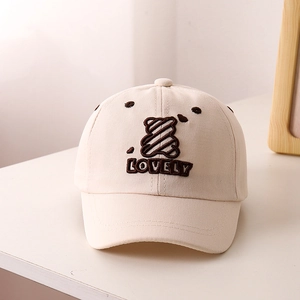 Detailed close-up of beige cotton baseball cap with bear and LOVELY embroidery