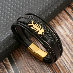 Detail of black multi-strand leather bracelet with golden fishbone and magnetic clasp