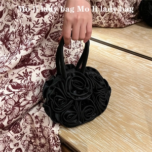 Detailed shot of handmade black satin rose flower handbag with double top handles