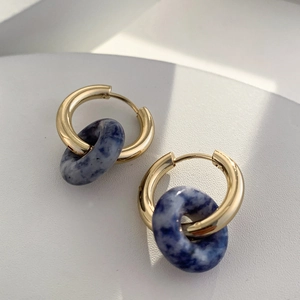 Detail of 18K gold hoop earrings featuring natural blue marble stone ring pendants