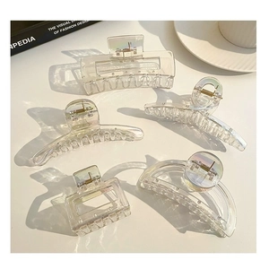 Detail view of five assorted colorful transparent acrylic hair claws on a white background