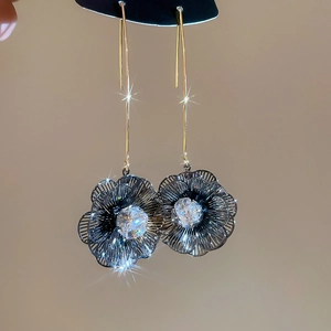 Détail macro de boucles d'oreilles fleur plaquées or 18 carats avec zircon brillant