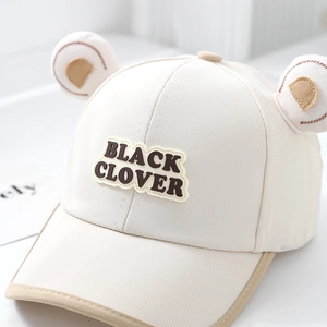 Détail macro d'une casquette en coton beige pour enfant avec oreilles d'ours en peluche