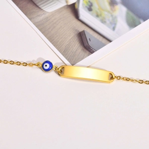 Golden stainless steel bracelet with blue evil eye charm and customizable blank metal bar