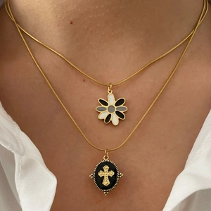 Stacked 18K gold plated titanium necklaces featuring floral and cross enamel pendants