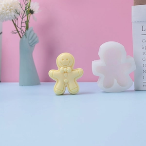 Detail of white silicone gingerbread man mold next to a yellow aromatherapy candle model