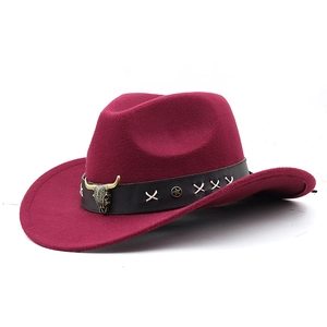 Close-up of burgundy cowboy hat with bull head metal emblem and leather decorative band