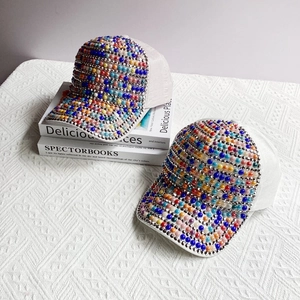 Detailed view of colorful pearls and rhinestones on stylish cotton baseball caps