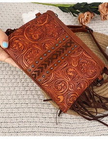 Detailed view of bohemian faux leather bag featuring floral embossing and long tassels