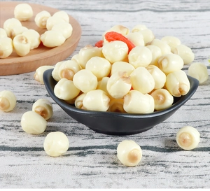 Detail of dried white lotus seeds with goji berries in a black ceramic bowl