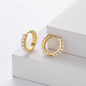 Detailed close-up of S925 sterling silver hoop earrings with small white pearls