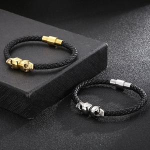 Detailed close-up of woven leather bracelets with gold and silver skull charms