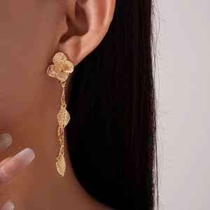 Elegant gold clover earrings with cascading leaf pendants on model from a side angle view