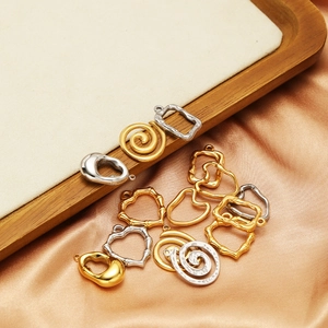 Polished heart and geometric stainless steel pendants on silk and wood tray