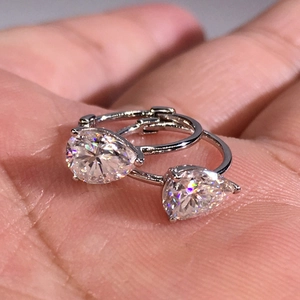 Elegant teardrop gemstone hoop earrings in polished silver metal held in hand