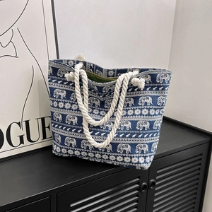 Navy blue canvas tote bag with elephant print and white rope handles on display
