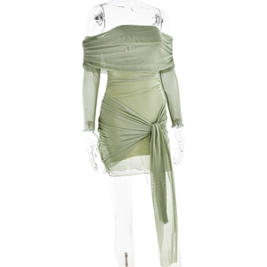 Détail d'une robe en tulle plissée vert clair avec col Bardot et nœud décoratif élégant