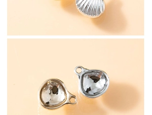 Macro view of shell-shaped jewelry pendants in gold and silver finish with wave textures