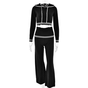 Detail view of the black knitted two-piece set with white stripe accents on the hoodie