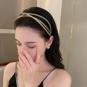 Serre-tête doré avec chaînes croisées et strass brillants, accessoire de mode élégant