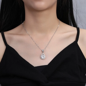 Close-up of 2 carat heart and arrow zircon pendant necklace on female collarbone