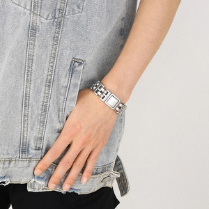 Detail of silver dual-row stainless steel watch-style link bracelet on a male wrist