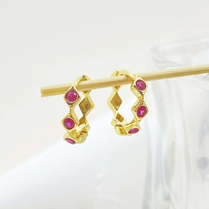 Detail of gold geometric hoop earrings with red rubies and S925 silver hallmark