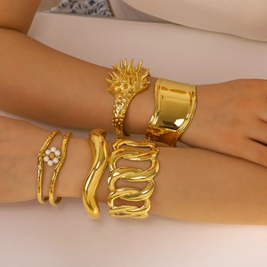 Golden chunky stainless steel bracelets in minimalist designs worn on arms