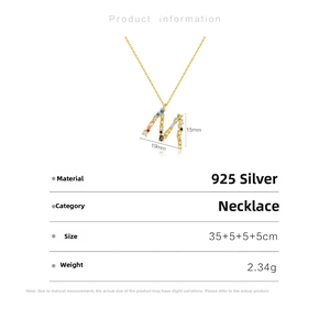 Macro view of gold plated 925 silver letter M necklace with colorful zircon stones
