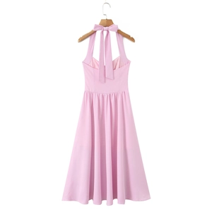 Detail of elegant pink halter neck dress featuring a delicate bow tie and sleek design