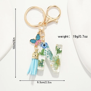 Detail of resin letter N keychain with dried flowers, blue butterfly, and tassel dimensions