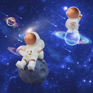 Astronaut resin sculpture set with rose gold accents on lunar and stellar bases