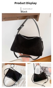 Detail view of black faux suede tote bag with silver zipper and adjustable strap