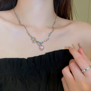 Collier cœur argenté avec pierre rose et cristaux colorés sur le cou du mannequin