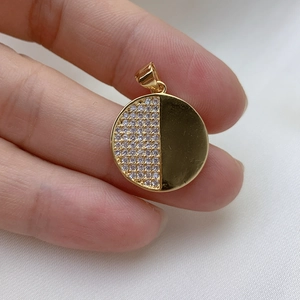 Gold plated circular pendant featuring half-paved zircons and half-polished metal surface