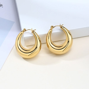 Macro shot of thick gold hollow teardrop earrings with high-polished mirror finish