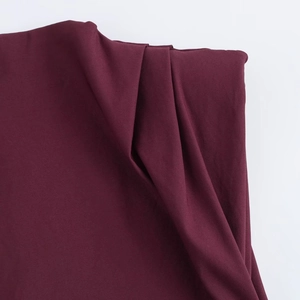 Detail of burgundy pleated fabric with fine knit texture and elegant drape effect