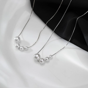 Elegant four-pearl gradient necklace on s925 silver chain over high-contrast background