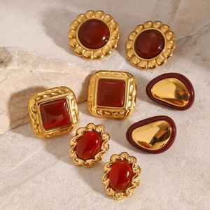 Retro gold stainless steel earrings set with red agate stones on a textured stone base