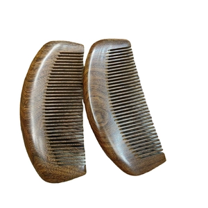 Set of two curved black sandalwood hair combs with natural wood grain on white background
