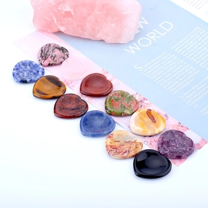 Polished natural crystal heart worry stones arranged on a magazine background