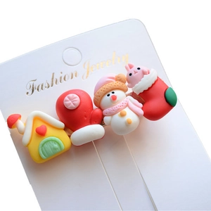 Macro view of Christmas resin hair clips featuring snowman and reindeer on a white card