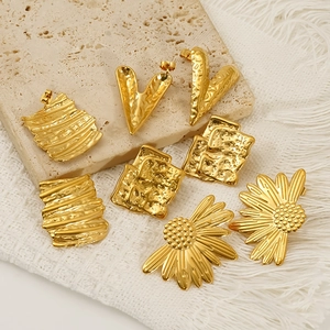 Golden stainless steel floral and irregular geometric earrings set on stone display